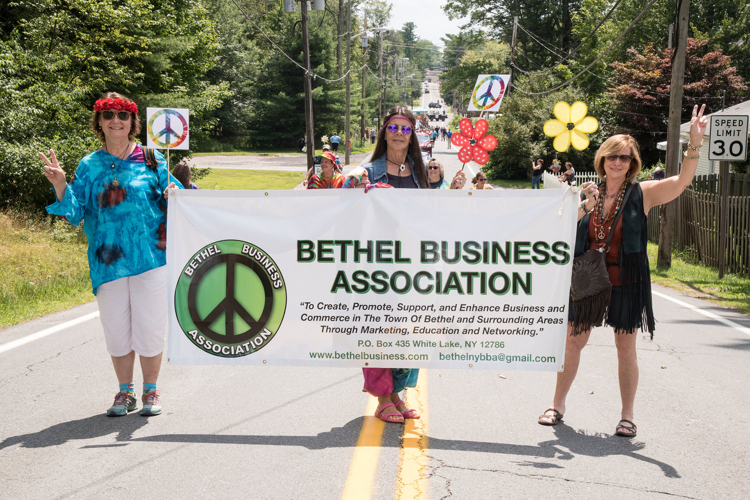 One of many local organizations to participate in the parade wearing “time period” attire, the Bethel Business Association’s (L-R) Julie Rozar, Suzanne White, and Carol Malek lead with the banner.